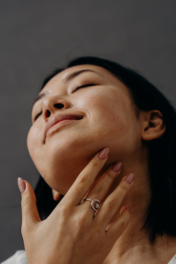 cta-02 Woman enjoying a facial massage with closed eyes and relaxed expression, promoting self-care and wellness.